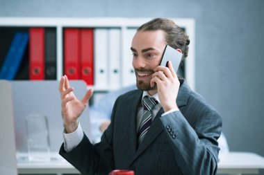 Ofiste telefonda konuşurken memnun işadamı