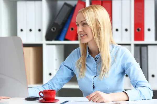 Vrouw office bedrijfsinformatie. Hij zit achter zijn bureau kijken naar monitor en glimlachen. — Stockfoto