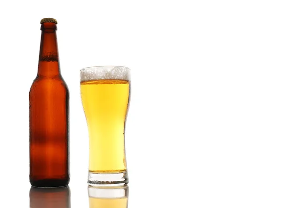 Bottiglia e un bicchiere di birra con schiuma isolata su sfondo bianco — Foto Stock