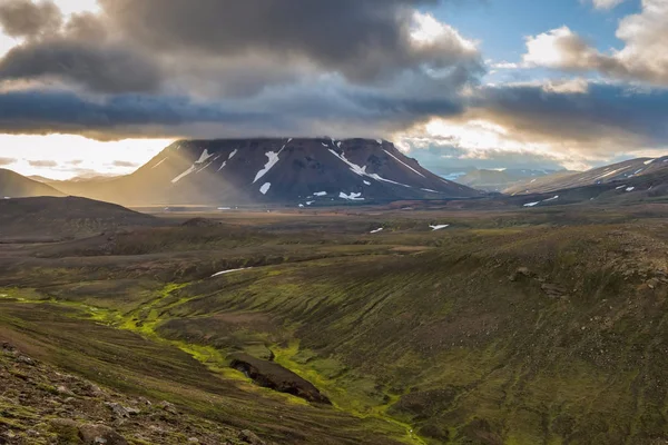 アイスランドの中西部は信じられないほどに見えます 雲に輝く太陽の光と緑豊かなアイスランドの風景の中にある山の輝き — ストック写真