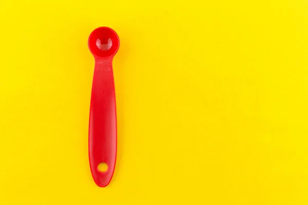 Cuchara Plástico Roja Sobre Fondo Amarillo —  Fotos de Stock