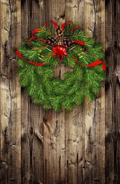 Corona de Navidad de ramitas de pino y bolas rojas en madera —  Fotos de Stock