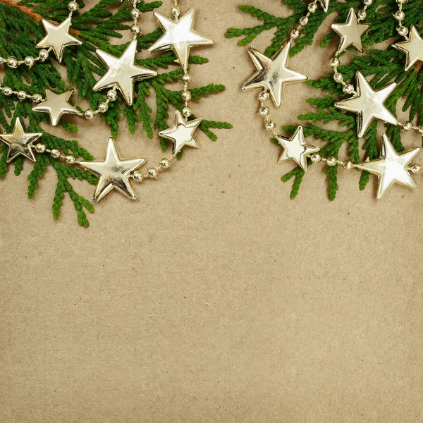 Cardboard with evergreen twigs and Chrisrmas garland — Stock Photo, Image