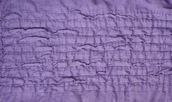 Tecido roxo com dobras costuradas irregulares — Fotografia de Stock