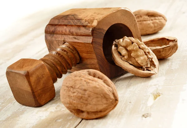 Nutcracker with walnuts on aged wood — Stock Photo, Image