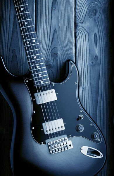 Vintage elctric guitar on wood background, blue image