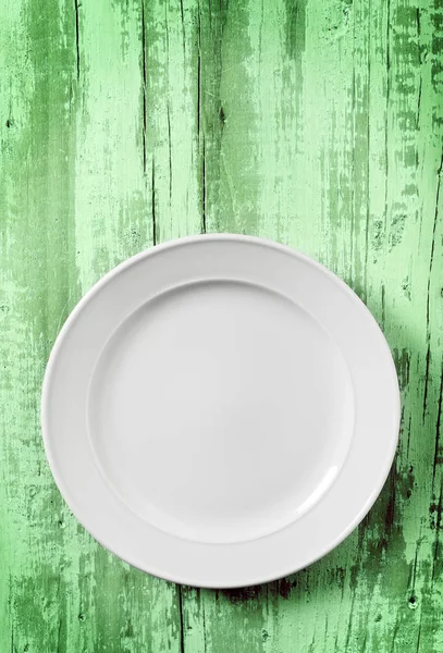 Prato vazio branco em madeira verde — Fotografia de Stock