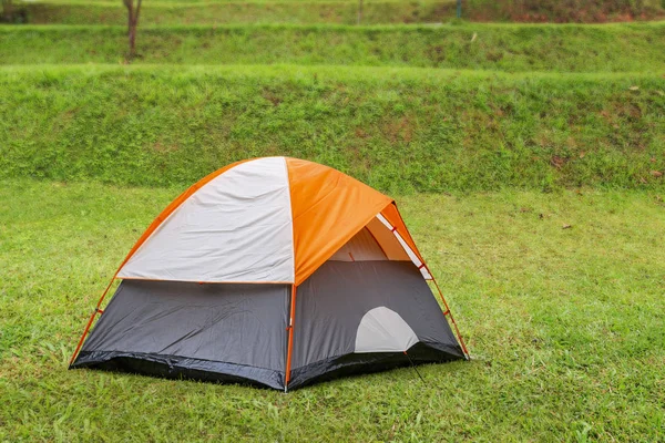 Turuncu dome çadır kamp sitedeki yeşil çimenlerin üzerinde — Stok fotoğraf