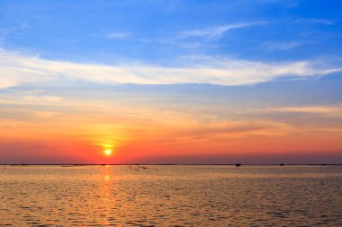 Deniz kıyısında ve yapısı kabuk çiftlik üzerinde günbatımı