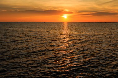 Deniz kıyısında ve yapısı kabuk çiftlik üzerinde günbatımı