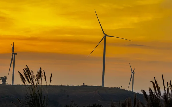Silueta větrné turbíny farmy nad Hora s orange sunset a — Stock fotografie