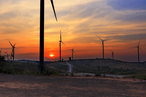 Silueta větrné turbíny farmy nad Hora s orange sunset a — Stock fotografie