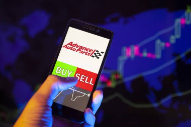 Yessentuki, Rusya - 27 Temmuz 2019: Akıllı telefon ekranında şirket logosu Gelişmiş Otomobil Parça Şirketi (Aap), hisse senedi grafiğinin arka planında Buy ya da Satış 'ı gösteren bir tüccar eli