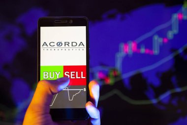 Yessentuki, Rusya - 27 Temmuz 2019: Akıllı telefon ekranında şirket logosu Acorda Therapeutics Inc. (Acor), hisse senedi grafiğinin arka planında Buy ya da sell 'i gösteren bir tüccar eli
