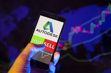 Yessentuki, Rusya - 27 Temmuz 2019: Akıllı telefon ekranında şirket logosu (Adsk), hisse senedi grafiğinin arka planında Buy ya da Satış 'ı gösteren bir tüccar eli
