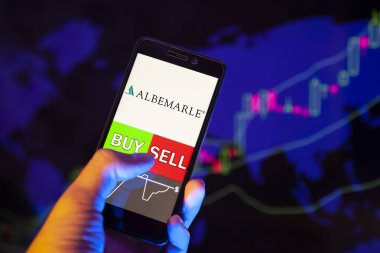 Yessentuki, Rusya - 27 Temmuz 2019: Akıllı telefon ekranında şirket logosu Albemarle Şirketi, Buy veya Satış 'ın hisse senedi grafiğinin arka planında yer aldığını gösteren cep telefonu taşıyan bir tüccar eli.