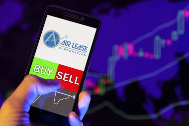 Yessentuki, Rusya - 27 Temmuz 2019: Akıllı telefon ekranında şirket logosu (Al), hisse senedi grafiğinin arka planında Buy veya Satış yapan bir tüccarın eli