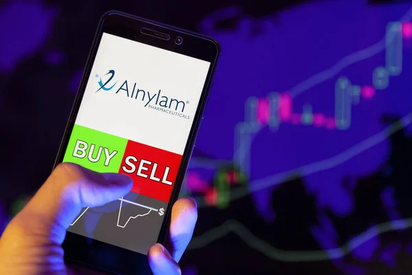 Yessentuki, Rusya - 27 Temmuz 2019: Akıllı telefon ekranında şirket logosu Alnylam Pharmaceuticals Inc, hisse senedi grafiğinin arka planında Buy ya da Satış 'ı gösteren bir tüccar eli