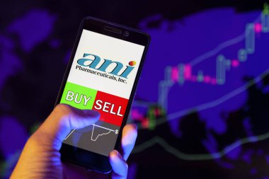 Yessentuki, Rusya - 25 Temmuz 2019: Akıllı telefon ekranında şirket logosu Ani Pharmaceuticals Inc, hisse senedi grafiğinin arka planında Buy ya da sell 'i gösteren bir tüccar eli