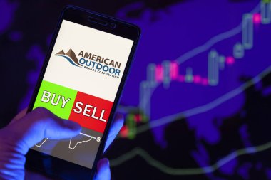 Yessentuki, Rusya - 25 Temmuz 2019: Akıllı telefon ekranında şirket logosu American Outdoor Mards Corporation (Aobc), hisse senedi grafiğinin arka planında Buy or sell 'i gösteren bir tüccar eli