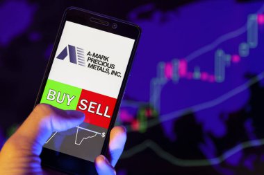 Yessentuki, Rusya - 25 Temmuz 2019: Akıllı telefon ekranında şirket logosu A-Mark Precious Metals Inc, hisse senedi grafiğinin arka planında Buy ya da Satış yapan bir tüccarın eli