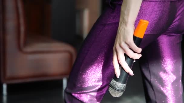 Die weibliche Hand hält ein Mikrofon in Großaufnahme. hat einen Finger am Mikrofon — Stockvideo