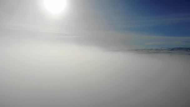 De opkomst van witte pluizige wolken met een prachtige zonnestralen op de achtergrond van bergtoppen en blauwe lucht. — Stockvideo