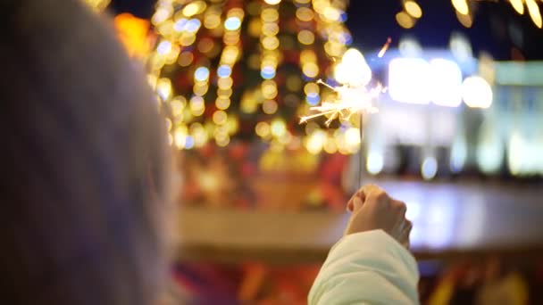 Donna mano che tiene sparkler davanti all'albero di Natale — Video Stock
