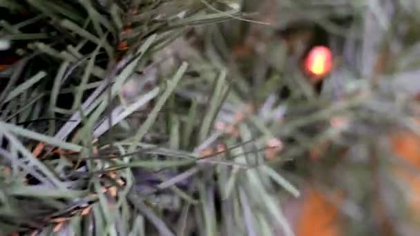 Fechar-se de grinalda de Natal a uma árvore de Natal artificial — Vídeo de Stock