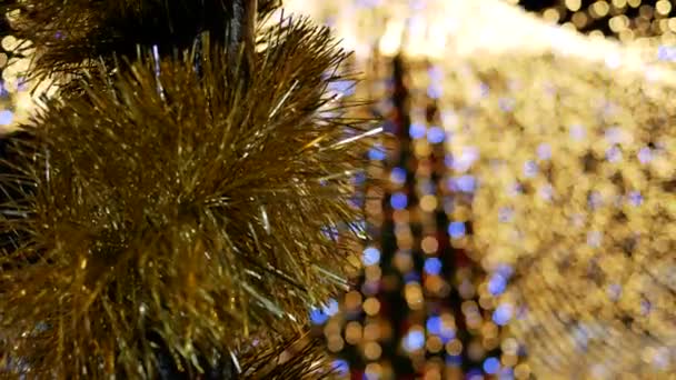 Close-up van knutsel op paal op de achtergrond lichte slinger kerstboom. Kopieerruimte — Stockvideo