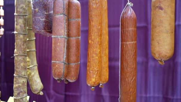 Копченая колбаса висит в магазине — стоковое видео