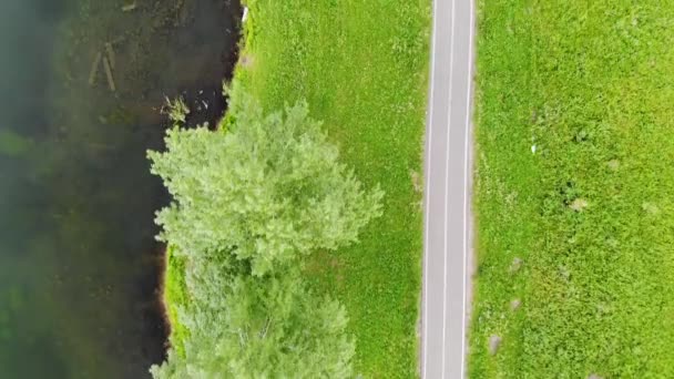 Vuelo aéreo por encima del camino a lo largo del lago con sospechosos en su pueblo — Vídeos de Stock