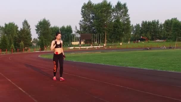 Kemerovo, Rusland - 11 juli 2018: Slow motion. jonge vrouw atleet lopen in het stadion op loopband — Stockvideo