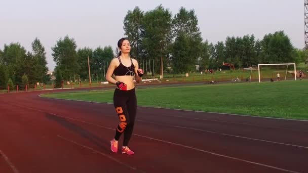 Kemerovo, Rusland - 11 juli 2018: Slow motion. jonge vrouw atleet lopen in het stadion op loopband buiten — Stockvideo