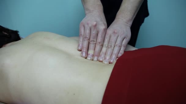 Врач остеопат делает массаж спины на позвоночнике пациентки — стоковое видео