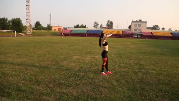 Kemerovo, Rusland - 11 juli 2018: jonge vrouwelijke atleet warmt zich buiten op in het stadion — Stockvideo