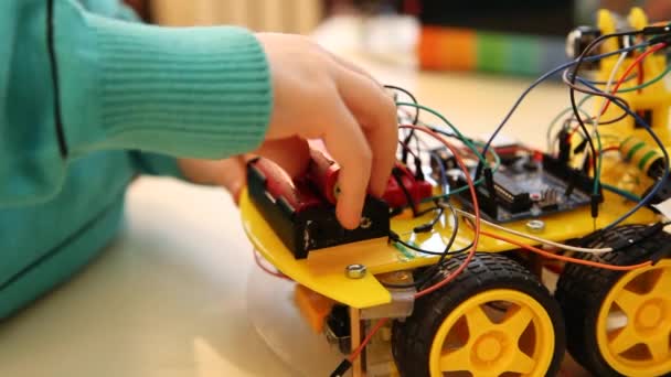 Robotics technology and STEM education class concept: Boy adjusts his robot. Programs for learning coding study in computer laboratory in school for kid — Stock Video