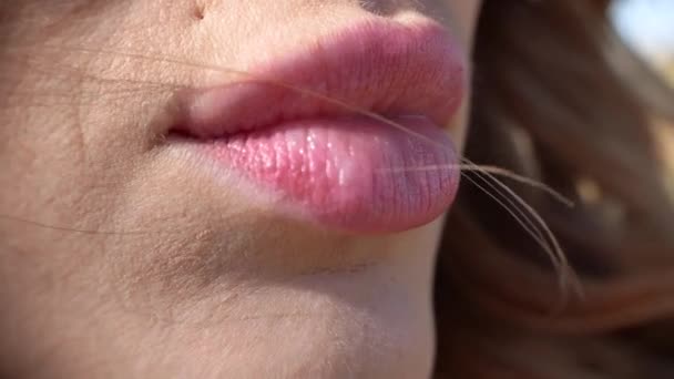 Крупный план макросъемки сексуальные губы красивой молодой женщины на открытом воздухе — стоковое видео