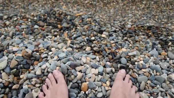 Primer plano de los pies en la playa de guijarros por mar al aire libre — Vídeos de Stock