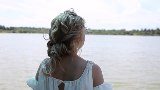 Bride one is standing back to camera looks on at lake — Stockvideo