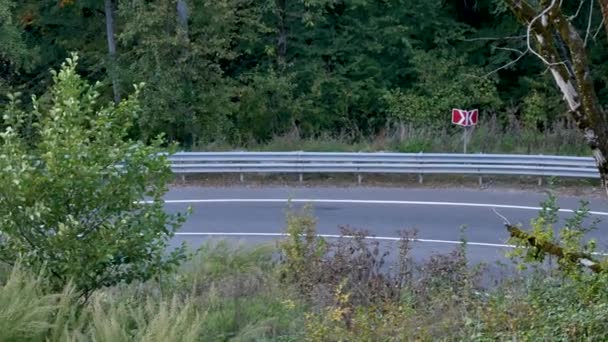 Asphalt road and signs in mountains. Car drives on road — 图库视频影像