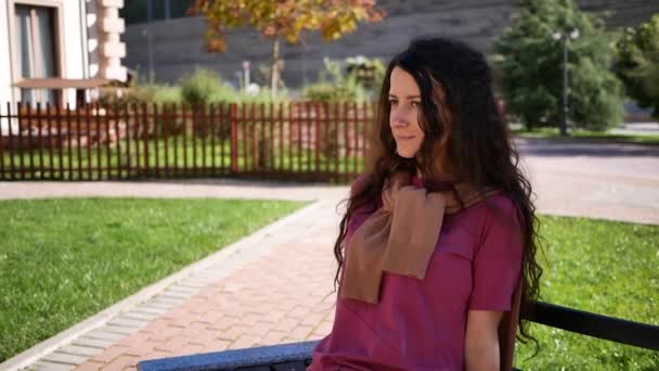 Portrait jeune femme assise sur le banc dans la journée d'été seul. à l'extérieur — Video