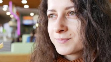 Genç, güzel esmer kız, fast food kafede gülümsüyor.. 