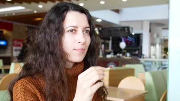 Giovane, bella ragazza bruna, sorridente in un fast food caffè . — Video Stock