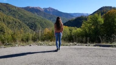 Özgürlük kavramı. Güzel genç bir kadın yazın gün batımında bir yerlerde uçuruma yaklaşır ve kollarını yana doğru açar.