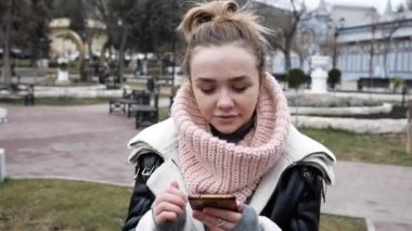 Akıllı telefonlu gülümseyen kadın evet hareketi yapıyor, kazanan belli, şans. Duygusal kadın harika haberler aldığı için heyecanlı. Akıllı telefon tutup sokakta geziniyor.