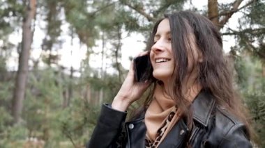 Telefonda konuşan gülümseyen güzel bir kadının portresi. Arayan kişiyi duyduğuna sevindi.