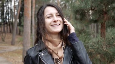 Telefonda konuşan gülümseyen güzel bir kadının portresi. Memnuniyetle arar.