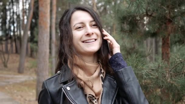 Portrait d'une belle femme souriante parlant au téléphone. Elle est heureuse d'appeler. — Video
