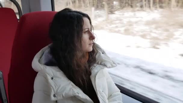 Portré fiatal nő lovaglás dolgozni, és néz ki az ablakon a nagy sebességű vonat — Stock videók
